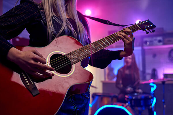 Woman playing a guitar on stage ata a concert